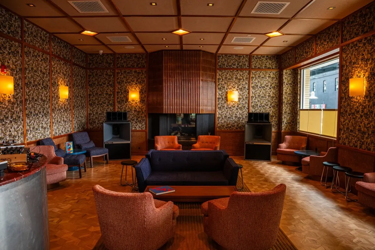 Percy's 70s-inspired sound lounge with orange armchairs, parquet floors, and Altec Lansing speakers